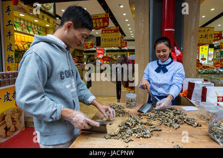 Yangshuo, Cina. La preparazione di arachidi fragile-Candy per l'insacco in vendita. Foto Stock