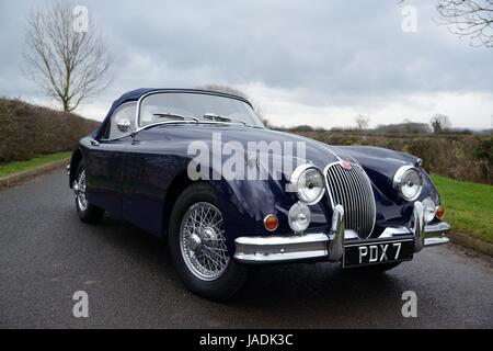 Jaguar XK150 parcheggiata su una corsia di campagna in un giorno d'inverno Foto Stock