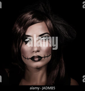 Scary ritratto di donna isolato su sfondo nero, mistero della notte, trucco terrificante, spooky zombie, giovane strega, festa di Halloween concept Foto Stock
