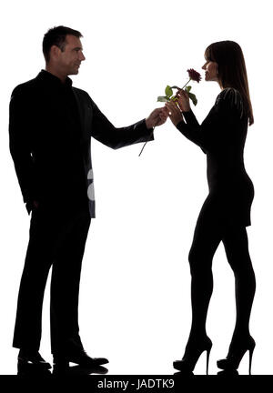 Uno gli amanti caucasico giovane uomo offrendo fiori di rose e la donna maleodoranti in studio silhouette isolati su sfondo bianco Foto Stock