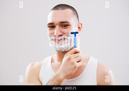 Giovane uomo è la rasatura la sua barba. Foto Stock