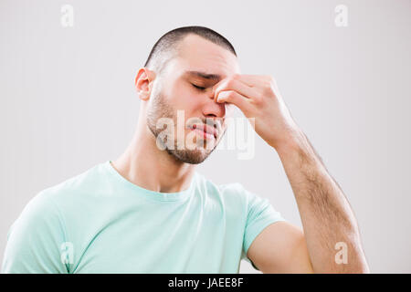 Ritratto di giovane uomo che sta avendo il dolore nel suo seno. Foto Stock