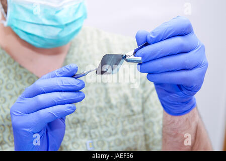 Close-up maschio medico dentista cercando ed esamina i denti X-ray shot. Messa a fuoco selettiva. Foto Stock