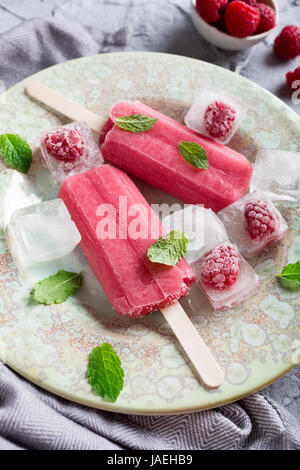 In casa lampone popsicles sulla piastra con ghiaccio e bacche. In estate il concetto di cibo. Foto Stock