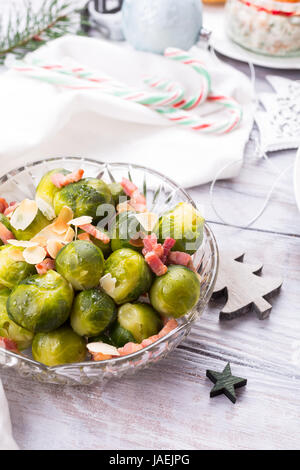 Cavoletti di Bruxelles con pancetta fritta e mandorle. Natale deliziose cene a tema tabella. Concetto di vacanza. Foto Stock