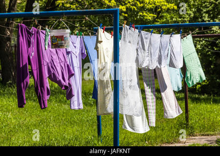Asciugatura lavanderia appendiabiti su abbigliamento Giardino esterno abbigliamento lavanderia appendiabiti su stoffa fresco giorno di sole Clothesline giardino Foto Stock