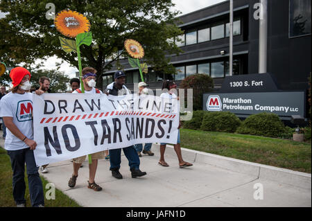 Più di un centinaio di persone protesta al di fuori della raffineria di maratona a Detroit come parte di un nationwide 'Dmaterie la linea " giornata di azione contro il Keystone XL Pipeline, Canadian tar sands e produzione di coke di petrolio nel sett. 2013. Il gruppo ha le sue esigenze per la raffineria di maratona, che si trova nella parte più inquinato il codice di avviamento postale in Michigan, 48217, e uno dei più inquinata in America. Il popolo postato il loro elenco di richieste di fronte alla raffineria che leggere: effettuare la restituzione per la comunità, la raffinazione di arresto tar sands, risanare l'ambiente colpito, ridurre le emissioni di anidride carbonica del 50% rispetto Foto Stock