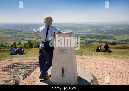 Regno Unito, Inghilterra, Shropshire, Il Wrekin, visitatore al vertice in appoggio sul Ordnance Survey punto trig Foto Stock