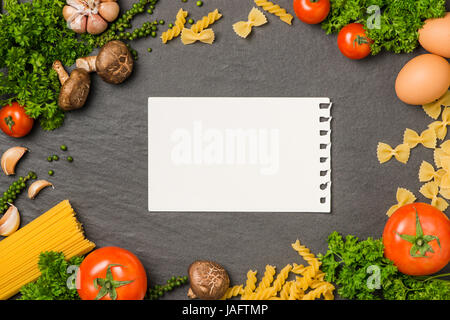Italiano Foto di spaghetti ricetta. Fermo mockup sul tavolo di cucina circondato con prodotti. Foto Stock