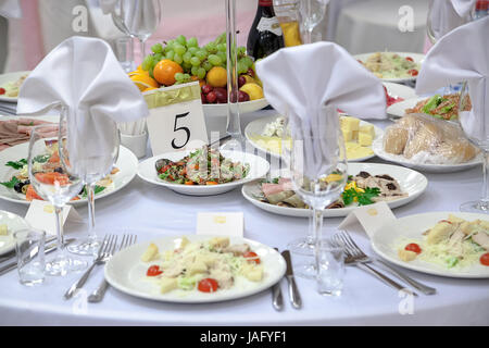Tavolo da pranzo impostazione in stile provenzale, con candele, lavanda, vintage stoviglie e posate closeup. Foto Stock