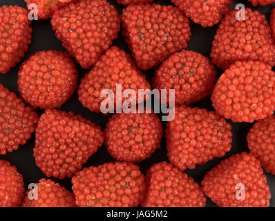 Molto vicino in vista di lampone caramelle sagomata su uno sfondo nero. Foto Stock