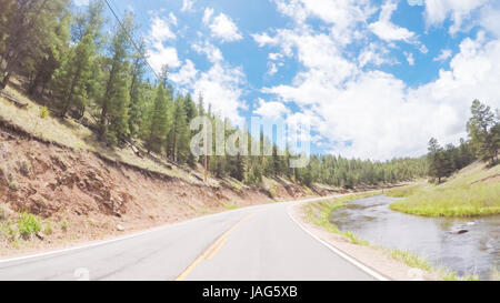 Denver, Colorado, STATI UNITI D'AMERICA-Maggio 27, 2017. POV punto di vista - Guida su piccola strada vicino al torrente di montagna nella zona rurale del Colorado occidentale. Foto Stock