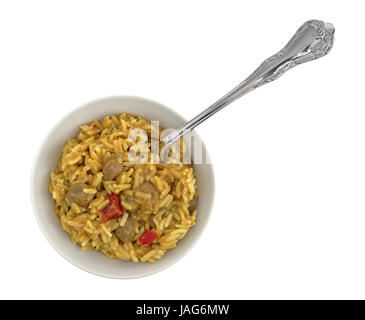 Vista dall'alto di korma salsa curry miscelato con riso pilaf in una ciotola bianca con una forcella nel cibo isolato su uno sfondo bianco. Foto Stock