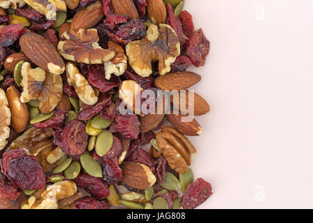 Top vista ravvicinata di omega 3 percorso misto dadi e frutta su una rosa tagliere. Foto Stock