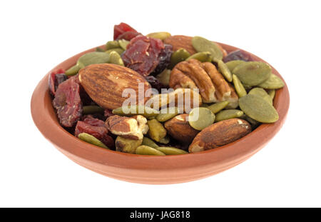 Omega 3 percorso misto dadi e ripieno di frutta di una piccola ciotola di argilla isolato su uno sfondo bianco. Foto Stock