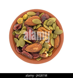 Vista superiore della omega 3 percorso misto dadi e frutta in una piccola ciotola di argilla isolato su uno sfondo bianco. Foto Stock