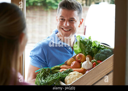 Uomo che fa la consegna a domicilio di verdure biologiche Box Foto Stock