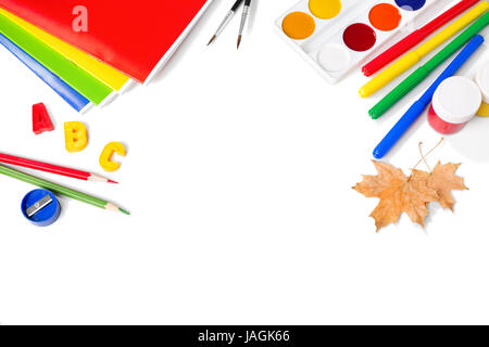 Attrezzature scolastiche con matite, vernici , pennelli e foglie di autunno isolato su bianco. Si torna a scuola concetto. Scuola articoli di cancelleria Foto Stock