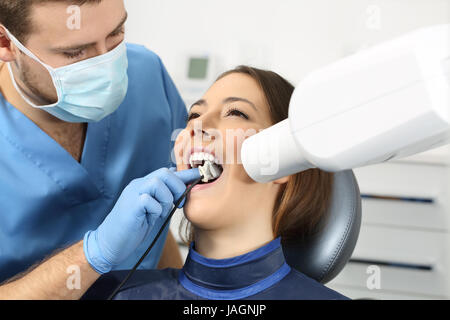 Dentista tenendo una radiografia dei denti di un paziente in un ufficio Foto Stock
