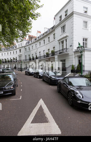 Londra, Regno Unito, 7 maggio 2017: mezzaluna in London Kensington con scure costose automobili su strada e fresco verde primavera foglie degli alberi Foto Stock