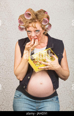 Incinta femmina hillbilly indulgere nella scatola di caramelle Foto Stock