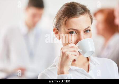 Giovane donna godendo di tazza di caffè nella sua pausa caffè Foto Stock