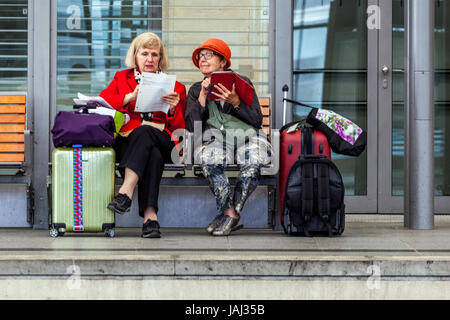 Due donne anziane con valigie in panchina e in attesa di un treno, Hauptbahnhof, Dresda, Sassonia, Germania Foto Stock