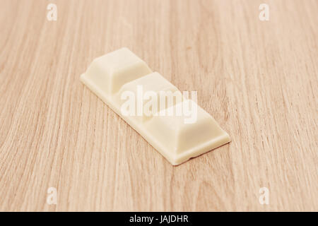 Il cioccolato bianco isolato su uno sfondo di legno Foto Stock