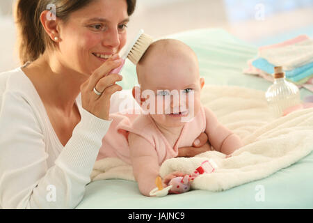 Il dado,baby,spazzola,Persone,madre,infante,ragazza,mantenere,spazzola, sorriso,fortunatamente,corredino,posizione addominale,abiti,piscina,ridere,giacciono,pettine, Foto Stock