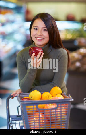 Una giovane donna cinese Shopping nel supermercato Foto Stock