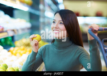 Una giovane donna cinese Shopping nel supermercato Foto Stock