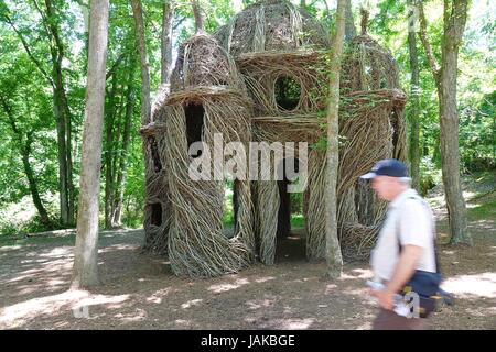 Un uomo cammina da 'una vista a ecco', una scultura Stickwork costruito da Patrick Dougherty con l aiuto di volontari che hanno fornito l'artista con alberelli Foto Stock