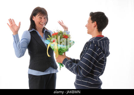 Mutter und ihr jugendlicher Sohn, er überreicht ihr einen Blumenstrauß vor weißem Hintergrund Foto Stock