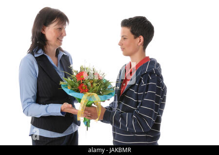 Mutter und ihr jugendlicher Sohn, er überreicht ihr einen Blumenstrauß vor weißem Hintergrund Foto Stock