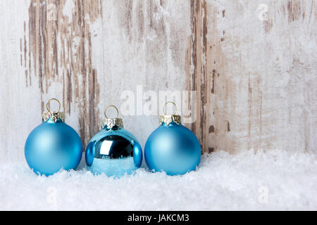 Weihnachten, Dekoration mit Holzhintergrund, Schnee und Weihnachtskugeln türkis Foto Stock