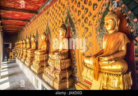 Reihe mit goldenen Buddha-Statuen auf dem Gelände des Grand Palace a Bangkok, in Thailandia Foto Stock