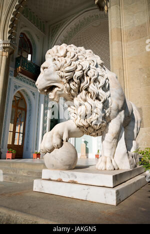 La scultura del leone con una sfera su uno sfondo di palace Foto Stock