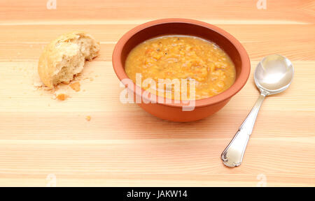 Semi-mangiato pane croccante rotolo con una ciotola di chunky zuppa di verdure Foto Stock