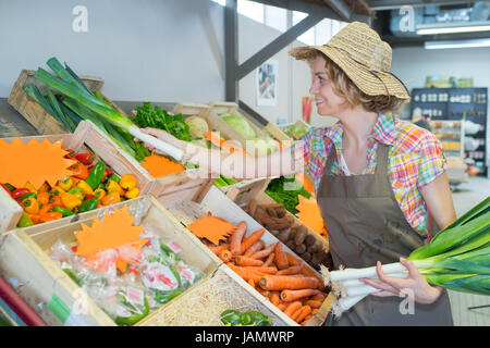 Shop assistant lavora al reparto di frutta nel supermercato Foto Stock