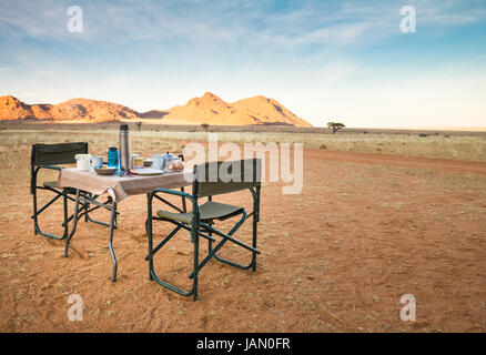 Camping tavolo e sedie nel deserto. ottima vista. sunrise. Foto Stock