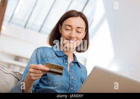 Donna collegata con il computer portatile e lo shopping online Foto Stock