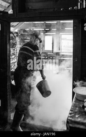 Campagna rumena, casari, vecchio processo tradizionale, il focolare al centro della casa. Maramures mountains. Foto Stock