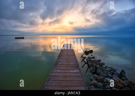 Il molo di legno e canotto in mare Foto Stock