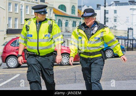 PCSO. La polizia del sostegno comunitario ufficiali pattugliano lungo la passeggiata sul lungomare nel West Sussex, Regno Unito. Foto Stock