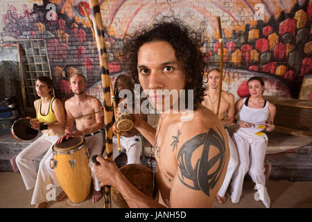 Bello il Latino capoeira expert con tattoo e strumento musicale Foto Stock