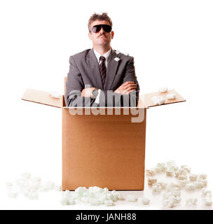 Imprenditore appare fuori della scatola di spedizione. Isolato su sfondo bianco Foto Stock