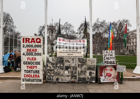 Cartelloni presso l'Accampamento della pace di Brian Haw a lungo termine anti-war protester in piazza del Parlamento, Londra, Regno Unito. Foto Stock