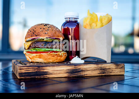 Un fast food set costituito da hamburger, gratuito potato, patatine fritte e bere Foto Stock