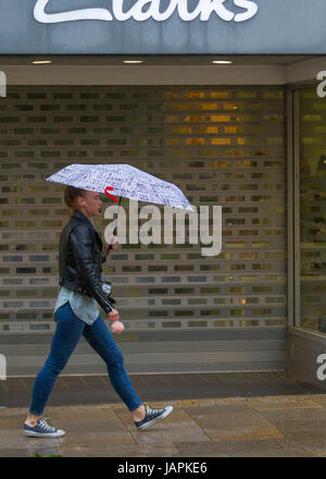 Fishergate, Preston, Lancashire, Regno Unito. 8 Giugno, 2017. Regno Unito Meteo. Gales & Heavy Rain in città. Acquazzoni torrenziali rendono difficile per gli acquirenti che lottano con le forti raffiche di vento, blustery e condizioni ventose. La previsione è per continuare la persistente e spesso heavy rain lentamente evolvendo verso est con forti venti. Credito: MediaWorldImages/Alamy Live News Foto Stock