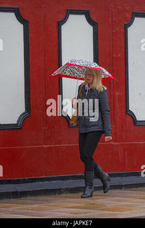 Fishergate, Preston, Lancashire, Regno Unito. 8 Giugno, 2017. Regno Unito Meteo. Gales & Heavy Rain in città. Acquazzoni torrenziali rendono difficile per gli acquirenti che lottano con le forti raffiche di vento, blustery e condizioni ventose. La previsione è per continuare la persistente e spesso heavy rain lentamente evolvendo verso est con forti venti. Credito: MediaWorldImages/Alamy Live News Foto Stock